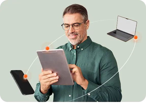 Person holding a tablet, with a phone and laptop connected around them